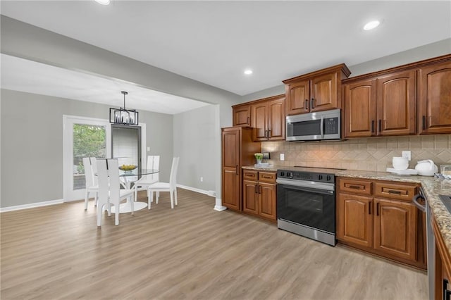 213 Lake Village Blvd, Blue Springs, MO 64014 - kitchen featuring brown cabinets, light wood-style flooring, stainless steel appliances, baseboards, and tasteful backsplash