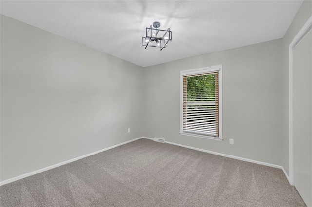 213 Lake Village Blvd, Blue Springs, MO 64014 - carpeted spare room with baseboards, a chandelier, and visible vents