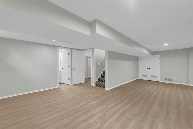 213 Lake Village Blvd, Blue Springs, MO 64014 - finished below grade area featuring visible vents, light wood-style flooring, baseboards, and stairway