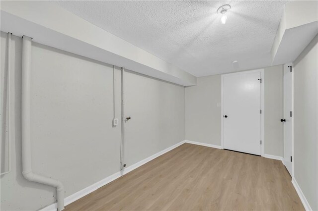 213 Lake Village Blvd, Blue Springs, MO 64014 - finished below grade area featuring a textured ceiling, baseboards, and light wood-type flooring