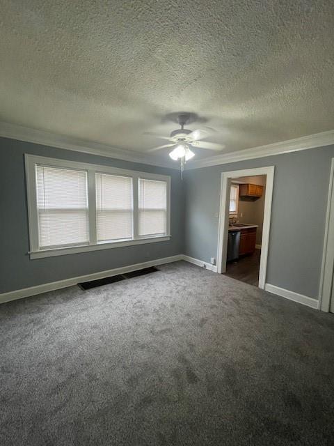 2120 68th Ter, Kansas City, MO 64132 - interior space with crown molding, ceiling fan, a textured ceiling, dark carpet, and baseboards