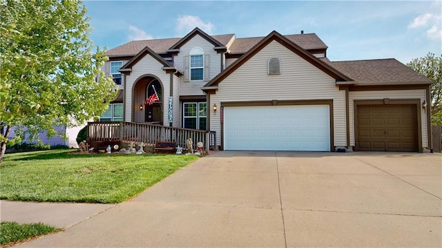 view of front of home featuring roof with shingles, an attached garage, concrete driveway, and a front yard