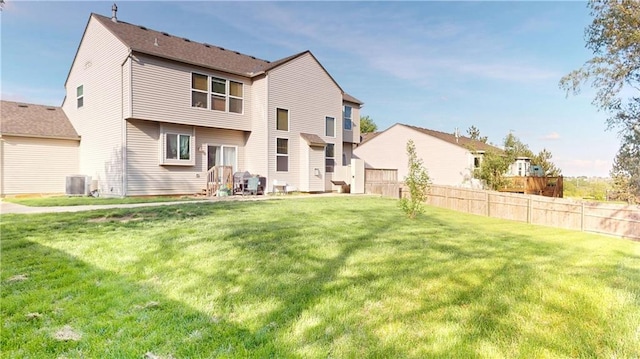 back of property with a yard, fence, and central AC unit
