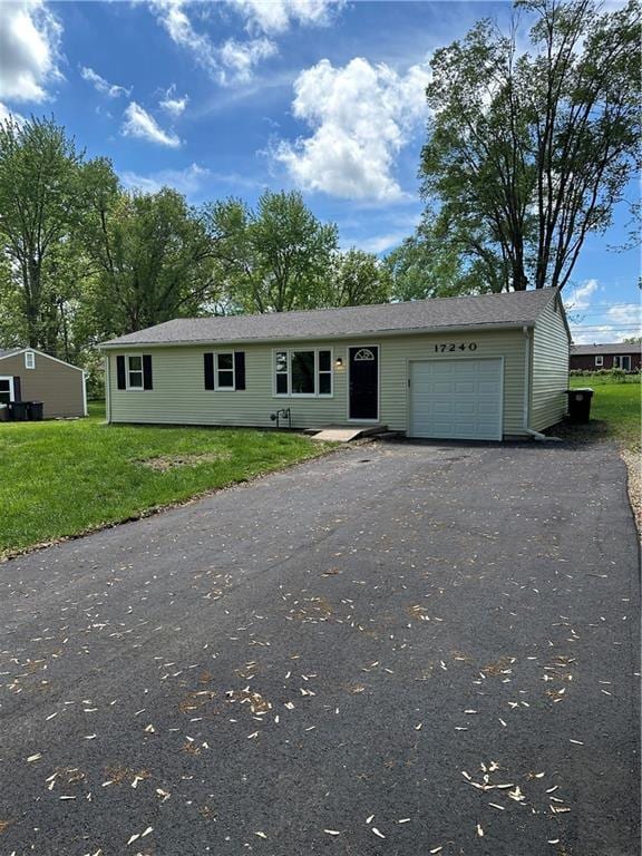 view of front of house with a garage, a front lawn, and aphalt driveway