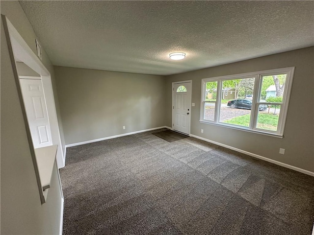 entrance foyer with baseboards, dark colored carpet, and a textured ceiling
