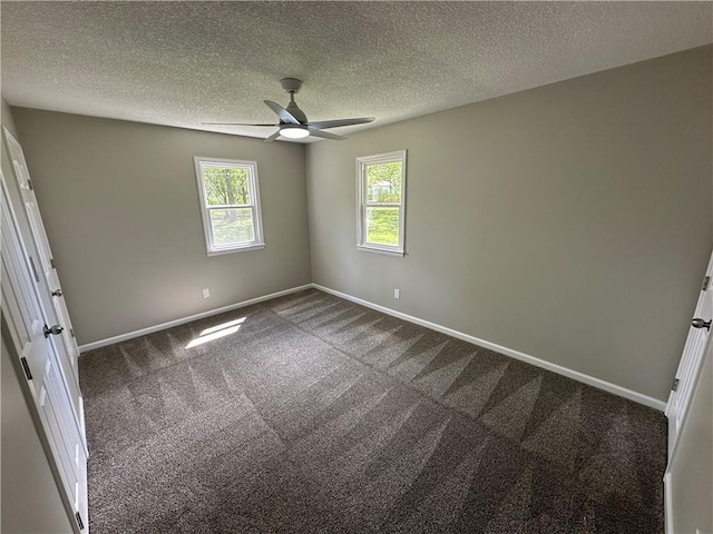empty room with dark carpet, a ceiling fan, and baseboards
