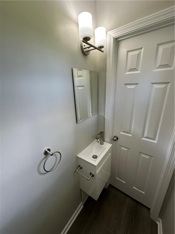 bathroom featuring vanity, baseboards, and wood finished floors