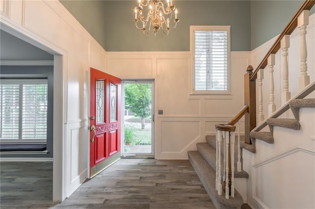 11801 Avila Dr, Kansas City, MO 64114 - foyer entrance with a decorative wall, stairs, a chandelier, wood finished floors, and wainscoting