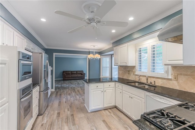 11801 Avila Dr, Kansas City, MO 64114 - kitchen with stainless steel appliances, crown molding, a peninsula, white cabinetry, and wall chimney exhaust hood