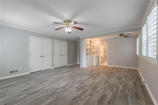 11801 Avila Dr, Kansas City, MO 64114 - unfurnished bedroom with two closets, wood finished floors, crown molding, ceiling fan, and ensuite bathroom