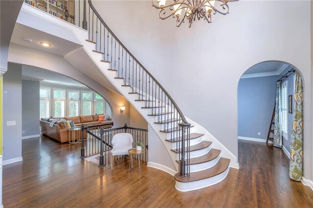 5701 W 148th Pl, Overland Park, KS 66223 - staircase with a high ceiling, arched walkways, wood finished floors, a chandelier, and ornamental molding