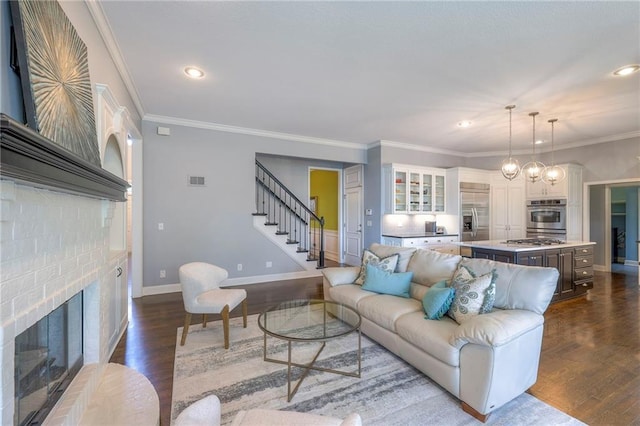 5701 W 148th Pl, Overland Park, KS 66223 - living room with stairs, a fireplace, dark wood-style floors, recessed lighting, and crown molding
