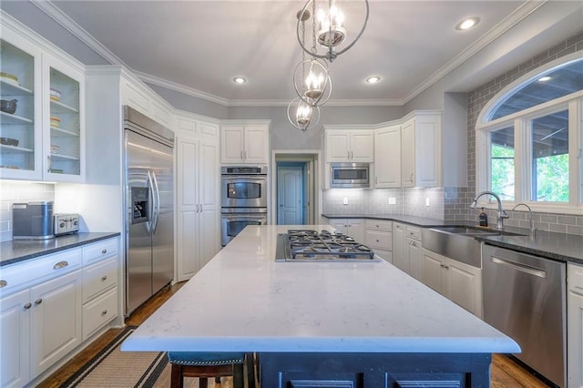 5701 W 148th Pl, Overland Park, KS 66223 - kitchen featuring built in appliances, white cabinetry, a center island, backsplash, and dark stone countertops