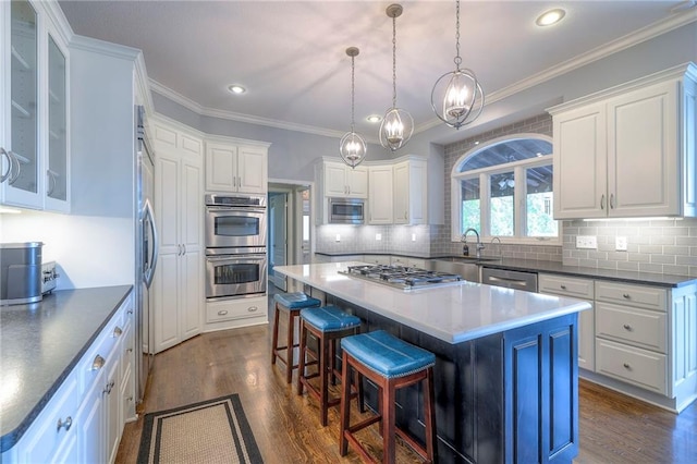 5701 W 148th Pl, Overland Park, KS 66223 - kitchen with stainless steel appliances, dark wood-type flooring, white cabinetry, a center island, and a breakfast bar