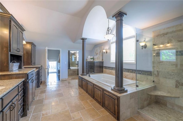5701 W 148th Pl, Overland Park, KS 66223 - bathroom featuring ornate columns, healthy amount of natural light, a garden tub, and stone tile flooring