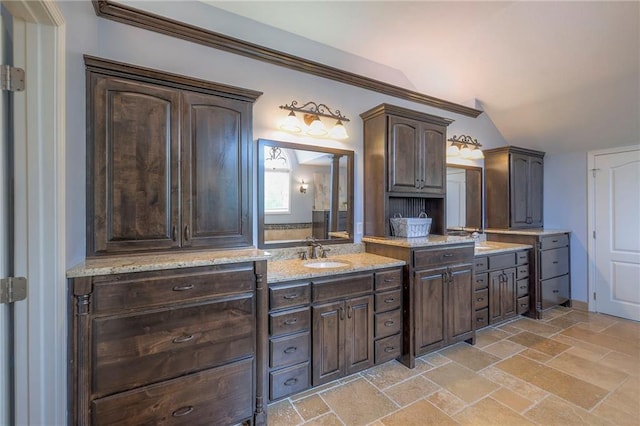 5701 W 148th Pl, Overland Park, KS 66223 - bathroom featuring double vanity, vaulted ceiling, and stone tile floors