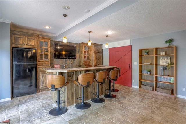 5701 W 148th Pl, Overland Park, KS 66223 - kitchen with freestanding refrigerator, glass insert cabinets, a kitchen breakfast bar, a textured ceiling, and hanging light fixtures