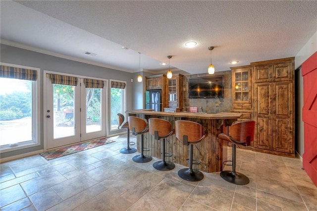5701 W 148th Pl, Overland Park, KS 66223 - indoor wet bar with freestanding refrigerator, crown molding, decorative light fixtures, recessed lighting, and a textured ceiling