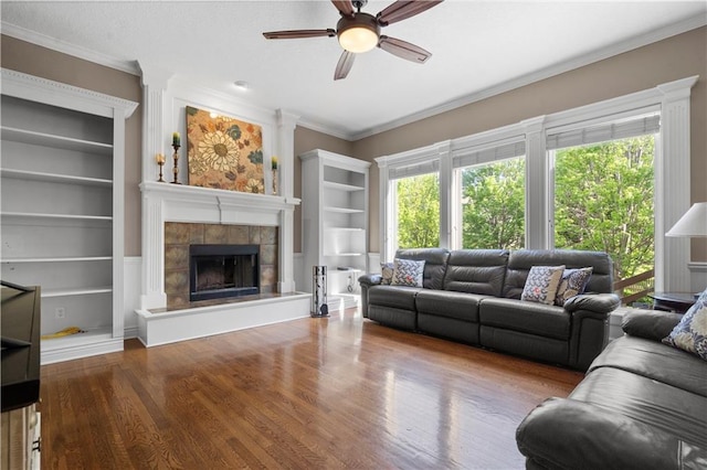 7406 W 145th Ter, Overland Park, KS 66223 - living room with ceiling fan, wood finished floors, built in shelves, a fireplace, and ornamental molding