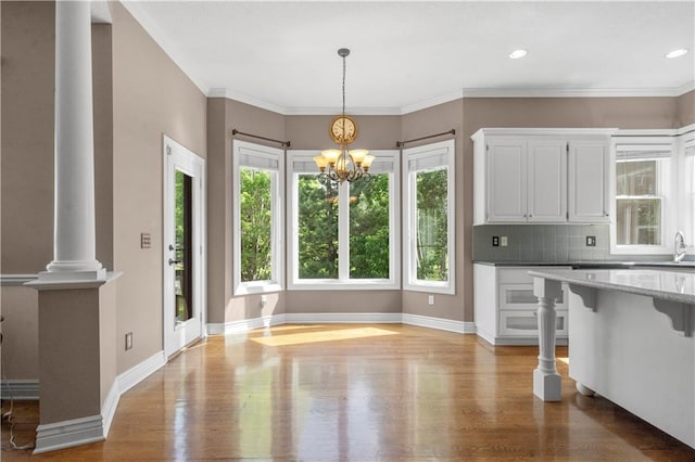 7406 W 145th Ter, Overland Park, KS 66223 - kitchen featuring plenty of natural light, white cabinets, decorative light fixtures, light wood finished floors, and recessed lighting