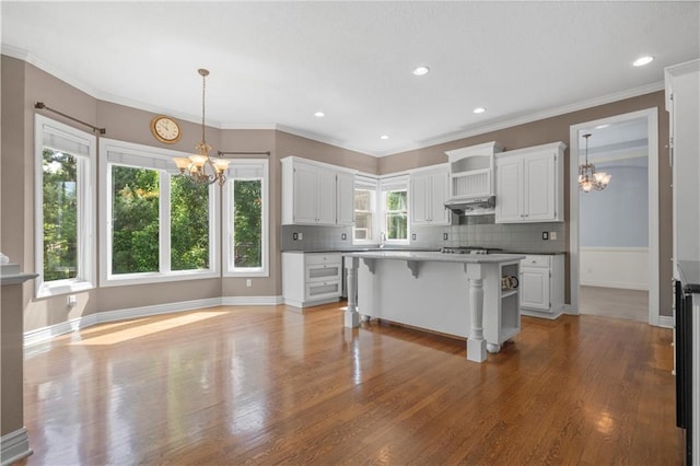 7406 W 145th Ter, Overland Park, KS 66223 - kitchen featuring a chandelier, a kitchen breakfast bar, white cabinets, crown molding, and recessed lighting