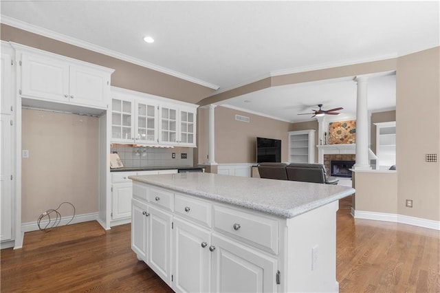 7406 W 145th Ter, Overland Park, KS 66223 - kitchen featuring ornate columns, a ceiling fan, a fireplace, wood finished floors, and ornamental molding