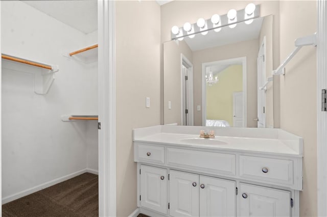 7406 W 145th Ter, Overland Park, KS 66223 - bathroom with vanity, a walk in closet, ensuite bathroom, and baseboards