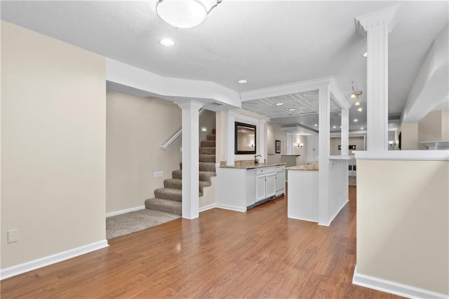 7406 W 145th Ter, Overland Park, KS 66223 - kitchen featuring white cabinets, decorative columns, wood finished floors, baseboards, and recessed lighting