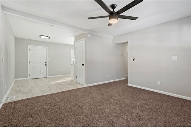 carpeted spare room featuring a ceiling fan, baseboards, and visible vents