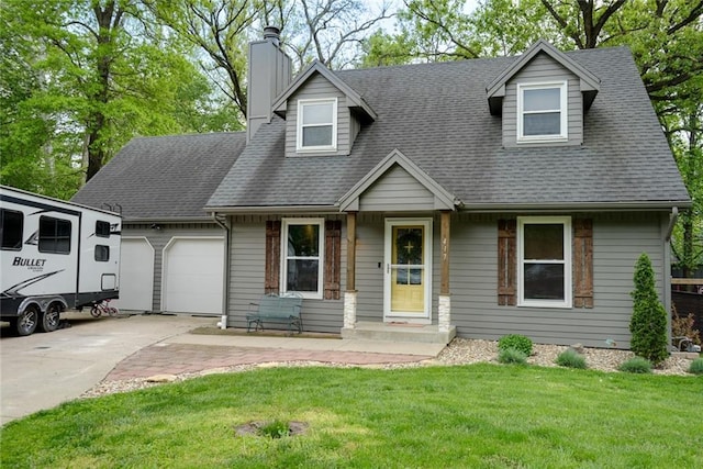 cape cod house featuring roof with shingles, an attached garage, a front yard, a chimney, and driveway