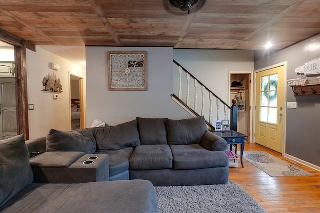 living area featuring wood ceiling, wood finished floors, and stairway