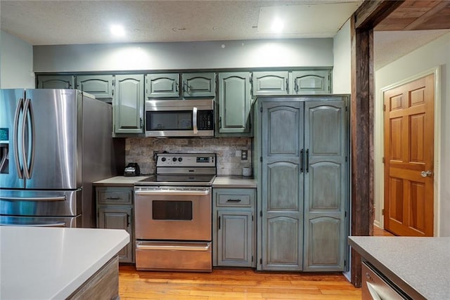 kitchen with light countertops, green cabinetry, and appliances with stainless steel finishes