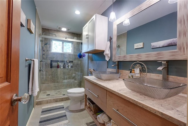bathroom featuring a sink, a stall shower, and toilet