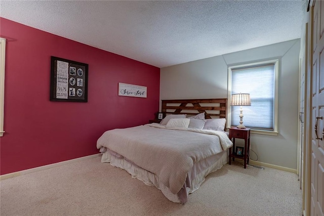 bedroom with carpet flooring, a textured ceiling, and baseboards