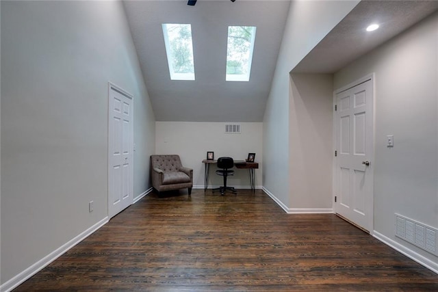 sitting room featuring visible vents, baseboards, lofted ceiling with skylight, and dark wood-style floors