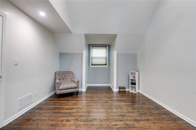 sitting room with baseboards, visible vents, wood finished floors, and lofted ceiling