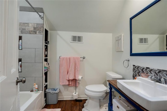 bathroom featuring visible vents, baseboards, wood finished floors, and toilet