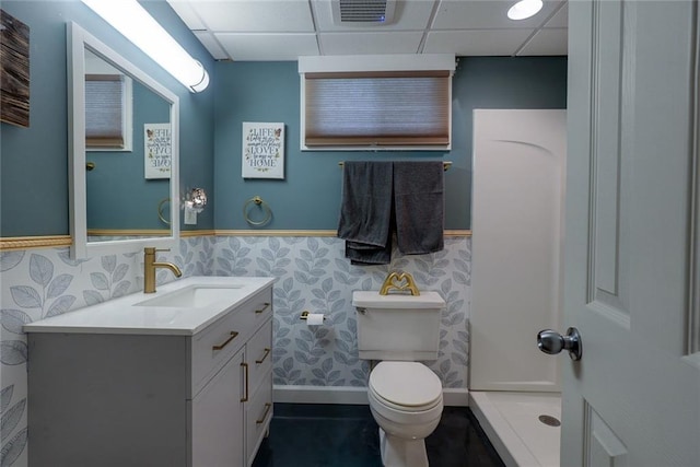 full bathroom featuring visible vents, a wainscoted wall, vanity, toilet, and a drop ceiling