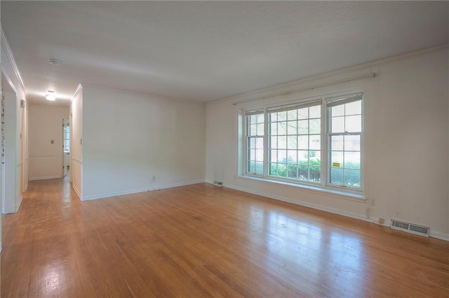 3913 Stonewall Ave, Independence, MO 64055 - spare room featuring visible vents, ornamental molding, light wood-style flooring, and baseboards