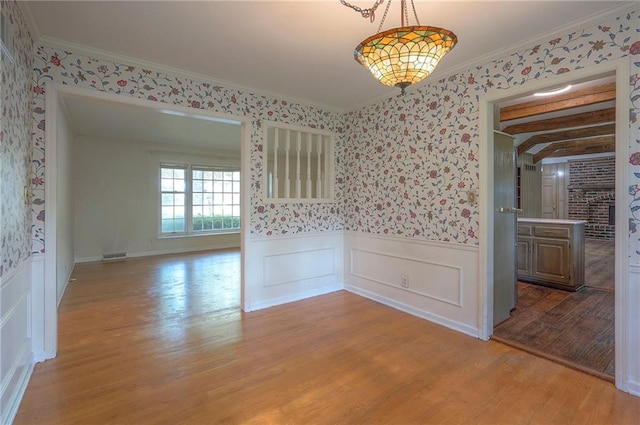 3913 Stonewall Ave, Independence, MO 64055 - unfurnished dining area with light wood finished floors, wainscoting, wallpapered walls, and visible vents