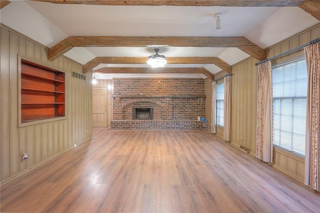 3913 Stonewall Ave, Independence, MO 64055 - unfurnished living room with wooden walls, wood finished floors, and visible vents