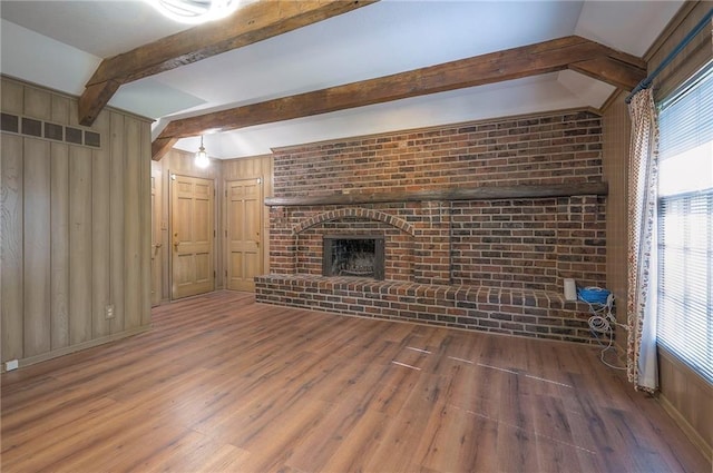 3913 Stonewall Ave, Independence, MO 64055 - unfurnished living room featuring plenty of natural light, wood finished floors, visible vents, and beam ceiling