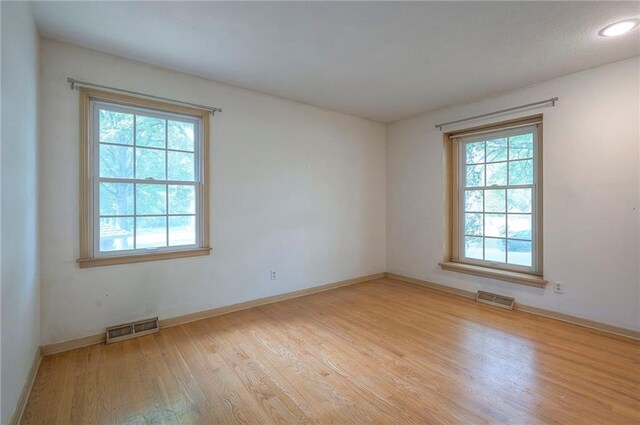 3913 Stonewall Ave, Independence, MO 64055 - empty room featuring visible vents, a healthy amount of sunlight, and wood finished floors