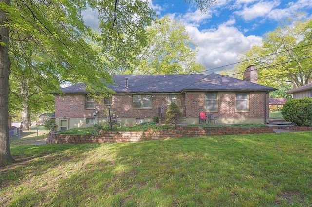 3913 Stonewall Ave, Independence, MO 64055 - back of house featuring brick siding, fence, a yard, and a chimney