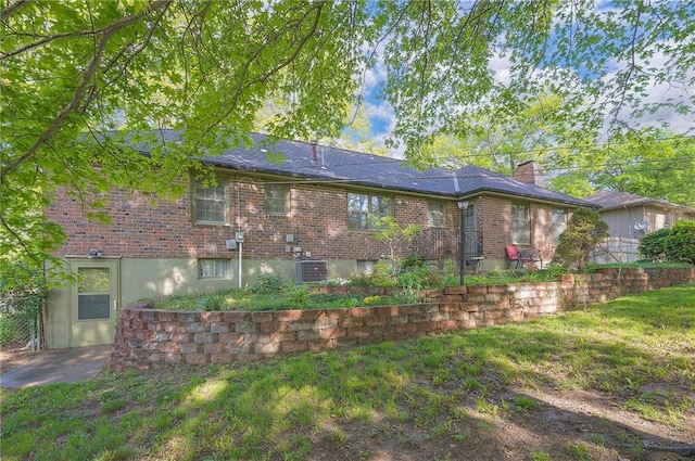 3913 Stonewall Ave, Independence, MO 64055 - back of property featuring brick siding, a yard, and a chimney
