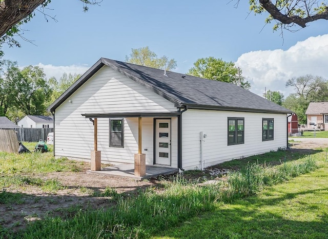 rear view of house featuring a patio and fence