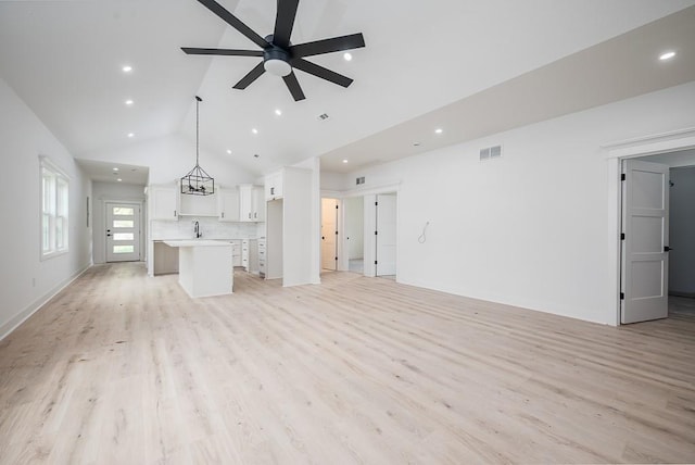 unfurnished living room with high vaulted ceiling, recessed lighting, and visible vents