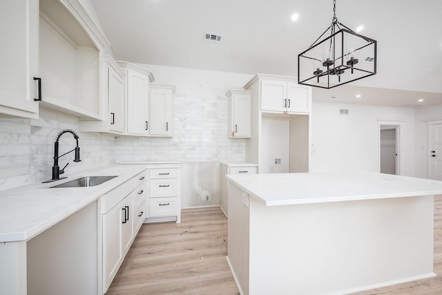 kitchen with a sink, recessed lighting, tasteful backsplash, a kitchen island, and visible vents