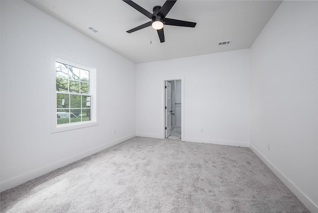 empty room featuring carpet, a ceiling fan, and visible vents