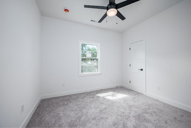 empty room with visible vents, carpet flooring, baseboards, and a ceiling fan